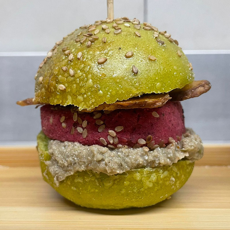 Burger vegetale con panino verde al sesamo, hamburger di barbabietola e crema di funghi